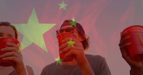 Friends Enjoying Sunset Gathering with Red Plastic Cups