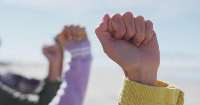 Diverse group of female friends raising fists at the beach - Download Free Stock Photos Pikwizard.com