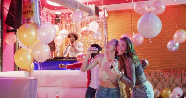 Image of two happy caucasian female friends singing karaoke at a nightclub bar - Download Free Stock Photos Pikwizard.com