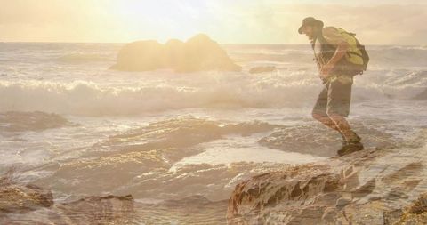 Hiker Exploring Rocky Shoreline at Sunset with Backpack