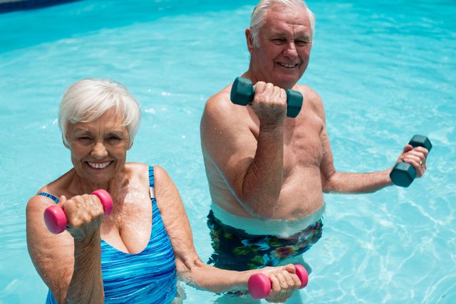 Senior couple enjoying water aerobics with dumbbells in a pool. Perfect for promoting active lifestyles, fitness programs for the elderly, health and wellness campaigns, and retirement community activities.