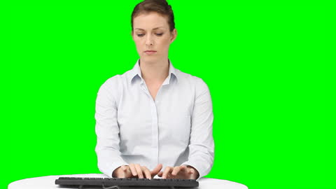 Serious Businesswoman Typing on Keyboard in Front of Green Screen