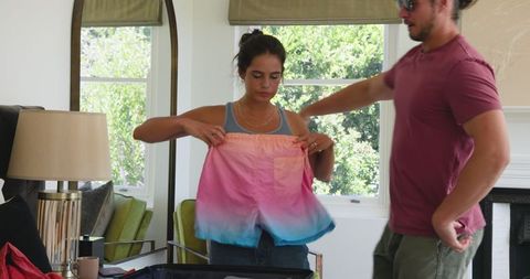 Couple exchanging colorful surprise gifts at home