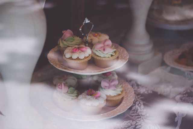 This visually appealing photograph features elaborately decorated cupcakes placed neatly on a tiered stand. Perfect for use in event planning or party planning content, this image highlights the intricate frosting designs and pastel colors suitable for weddings, birthdays, or other celebratory occasions. Use for blog posts, social media promotions, or print materials related to baking and event organizing.