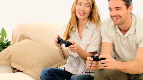 Cheerful Couple Enjoying Video Game on Sofa