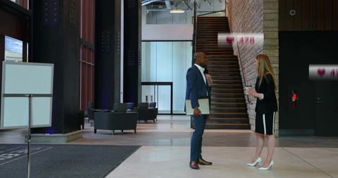 Colleagues discussing in modern office lobby