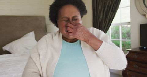 Senior Woman Sneezing in Bedroom During Quarantine
