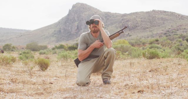 Hunter using binoculars in arid mountainous landscape - Download Free Stock Images Pikwizard.com