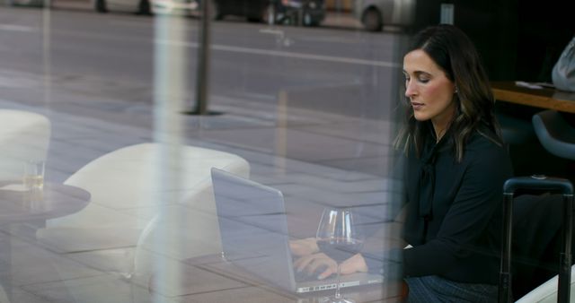 Businesswoman Working on Laptop in Modern Urban Café - Download Free Stock Images Pikwizard.com