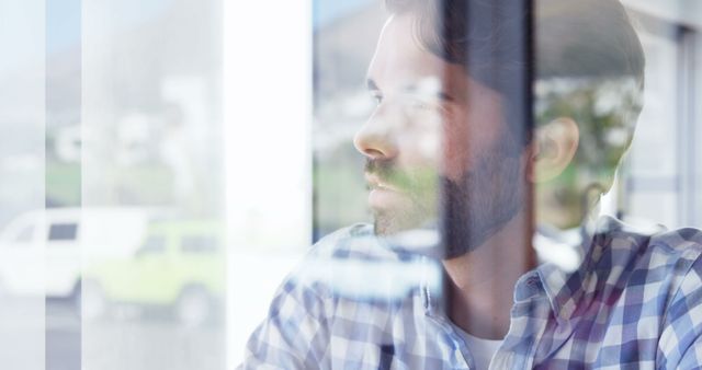 Close-up of thoughtful man gazing through window, reflecting outside view - Download Free Stock Images Pikwizard.com