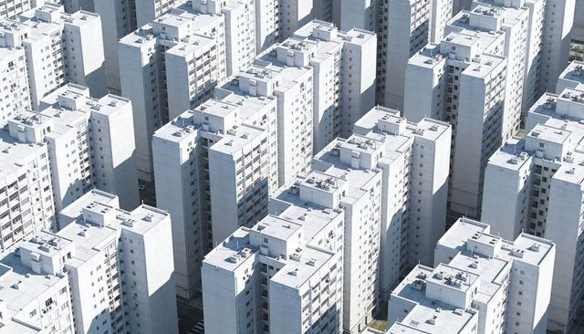 Aerial view of dense high-rise apartment towers forming geometric rooftop grid with hvac