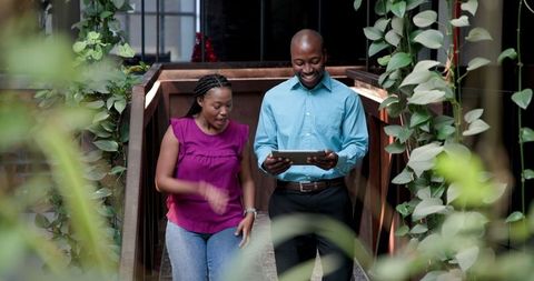 Colleagues Collaborating with Tablet in Modern Office Space