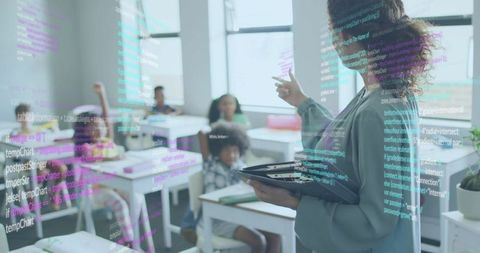 Teacher leading digital coding lesson in bright classroom with students using tablet