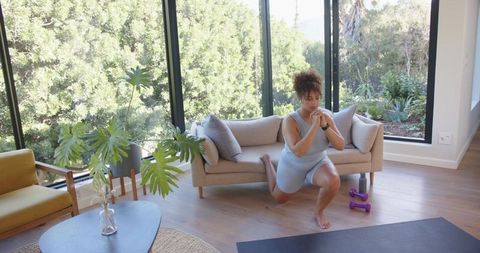 Woman performing lunge workout in sunlit living room minimalist home fitness routine
