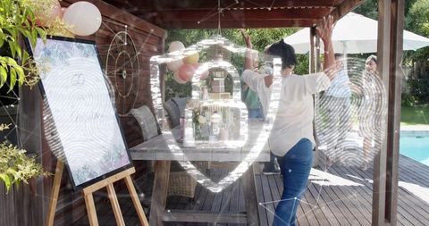 Mature woman celebrating 60th birthday on backyard deck with balloons, pergola and pool