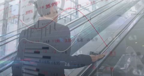 Businesswoman ascending escalator holding smartphone on handrail with financial charts