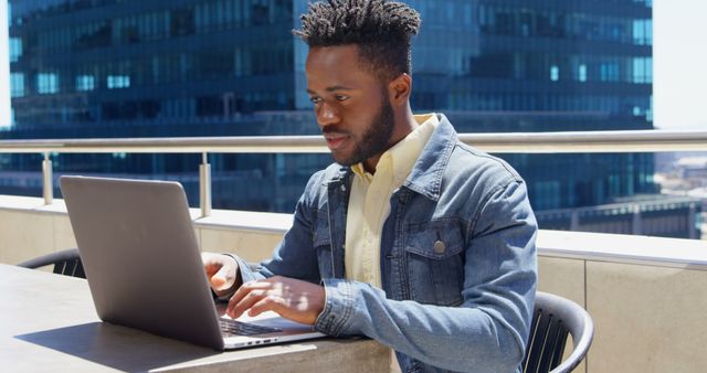 Young Man Working on Laptop on Outdoor Rooftop - Download Free Stock Images Pikwizard.com