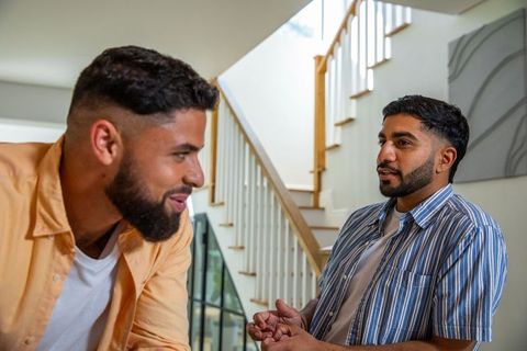 Diverse male friends chatting in modern home interior