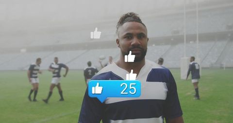 Rugby player standing on misty stadium pitch wearing navy-striped jersey with 25 likes