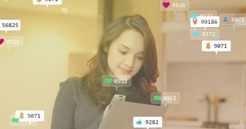Woman Interacting with Digital Notifications on Tablet in Warm Kitchen
