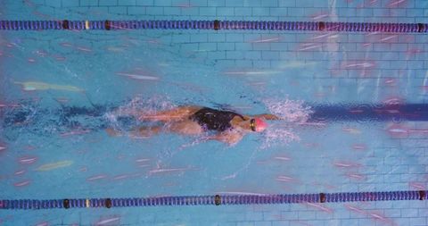 Professional swimmer gliding through pool lane during training session