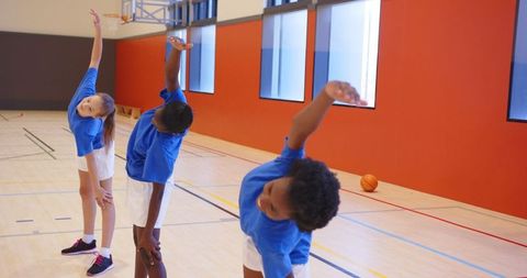 Teenagers Stretching in Gym for Basketball Safety