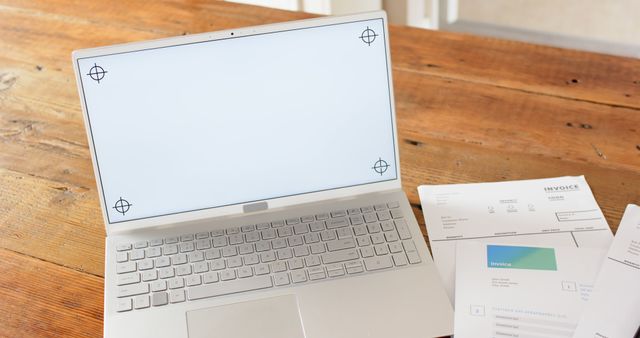 Laptop Displaying Calibration Marks with Paperwork on Wooden Desk - Download Free Stock Images Pikwizard.com