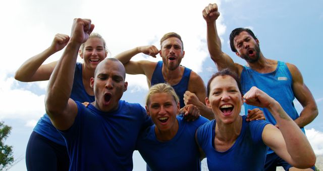 A group of five friends are seen celebrating outdoors, exuding excitement and joy. This image is perfect for portraying themes of friendship, teamwork, and positive energy in marketing materials, advertisements for team-building activities, or social media posts. It can also be used to illustrate outdoor events and achievements.