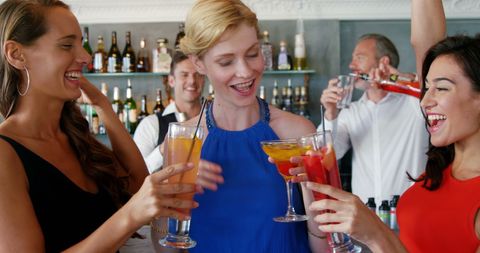 Friends Celebrating with Cocktails in Bar Setting
