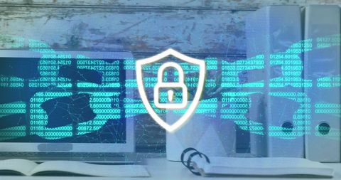 Cybersecurity shield with digital code overlay on office workspace