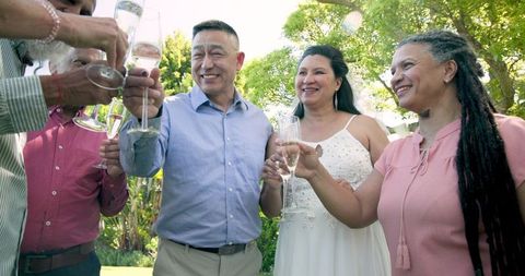 Joyful senior wedding celebration outdoors with diverse friends