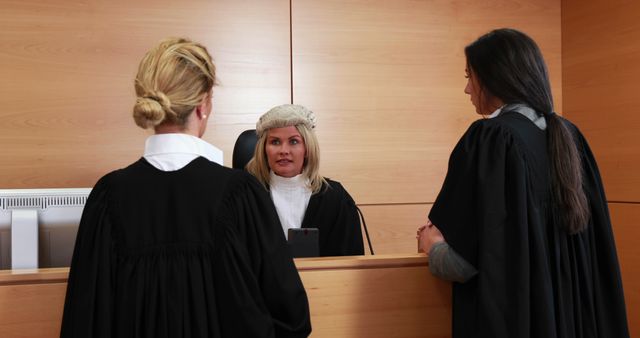 Female lawyers in wigs deliberate seriously in a courtroom setting. - Download Free Stock Photos Pikwizard.com