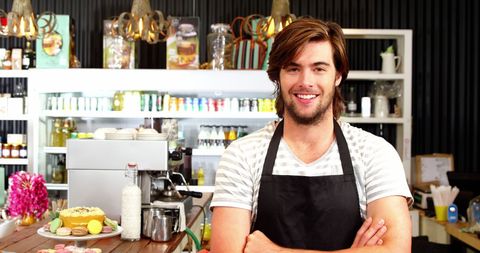 Smiling Male Waiter Standing in Modern Café Hospitality Setting