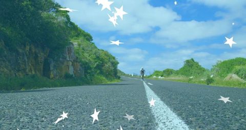 Cyclist venturing scenic countryside under blue sky