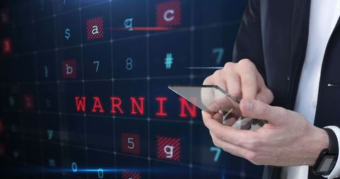 Businessman using smartphone with digital cybersecurity warning overlay