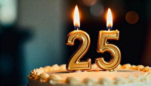 Golden 25 birthday cake candles burning on frosted cake close-up celebrating milestone