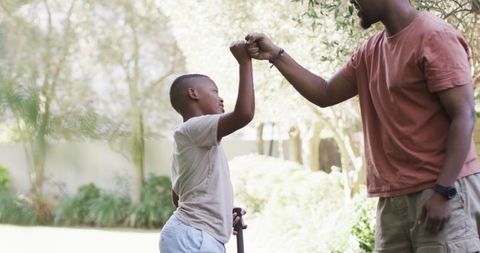 Father and Son Bumping Fists in Backyard Activity