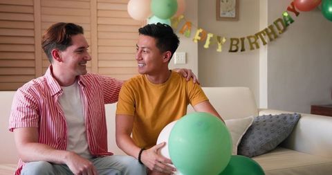 Happy Gay Couple Celebrating Birthday with Balloons at Home
