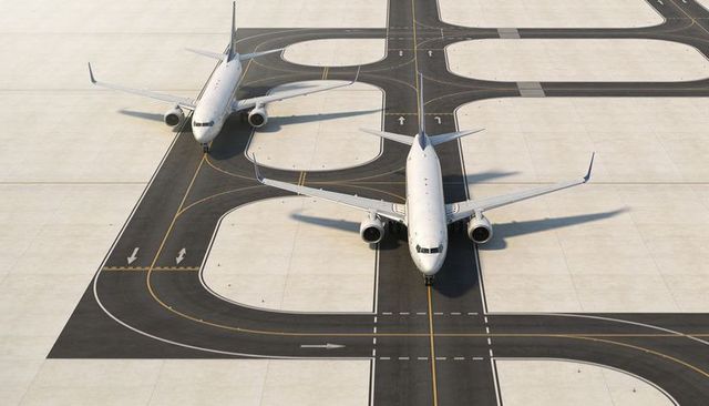 Narrow-body commercial jets taxiing on concrete ramp with precision taxiway markings