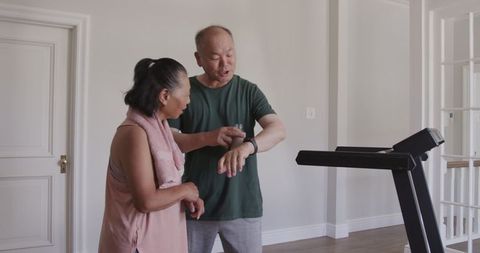 Asian couple embracing fitness lifestyle at home with treadmill