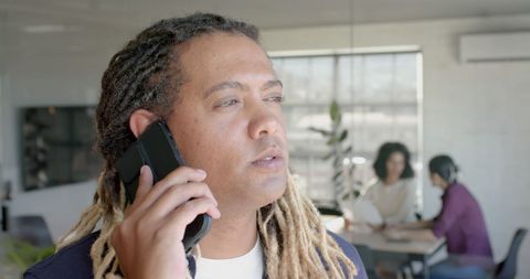 Businessman Communicating on Smartphone at Open-Plan Office