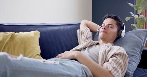 Relaxed Man Enjoying Music on Couch in Cozy Living Room