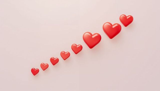 Diagonal row of glossy red hearts growing larger on pastel pink background minimalist valentine
