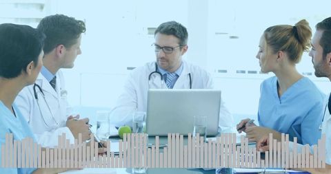 Leading doctor guiding medical team during clinical meeting with laptop and waveform