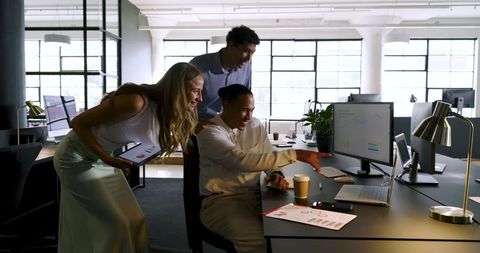 Colleagues Celebrating Office Success with Data Analysis