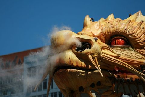 Golden mechanical dragon breathing steam in urban setting