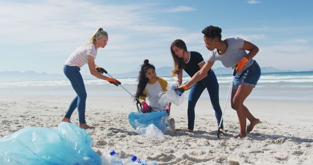 Group of diverse women working together collecting trash on beach, demonstrating community involvement in environmental cleanups. Perfect for topics on sustainability, conservation programs, and team-building initiatives.