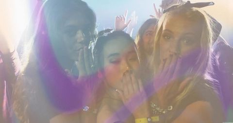 Three friends laughing wildly amidst club lights