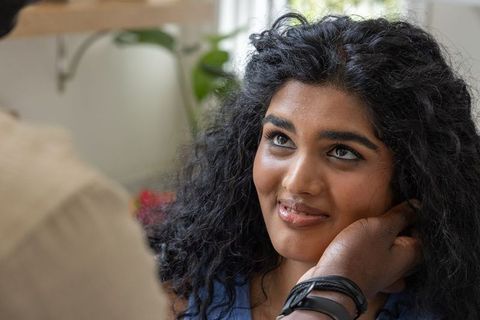 Indian woman gazing at african american partner holding her cheek during intimate cozy moment