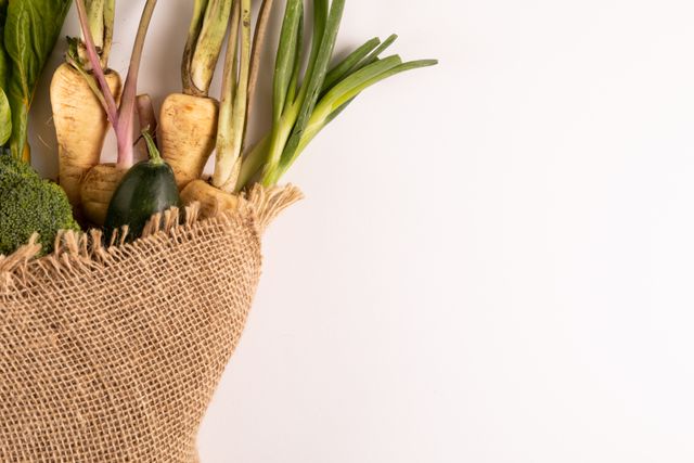 This image showcases fresh organic vegetables wrapped in burlap against a white background, emphasizing natural and healthy eating. Ideal for use in articles, blogs, and advertisements related to organic farming, sustainable living, healthy recipes, and eco-friendly lifestyles.